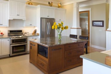 A delightful kitchen has all the amenities, including two separate farm-style sinks, a custom banquette and an abundance of work space.